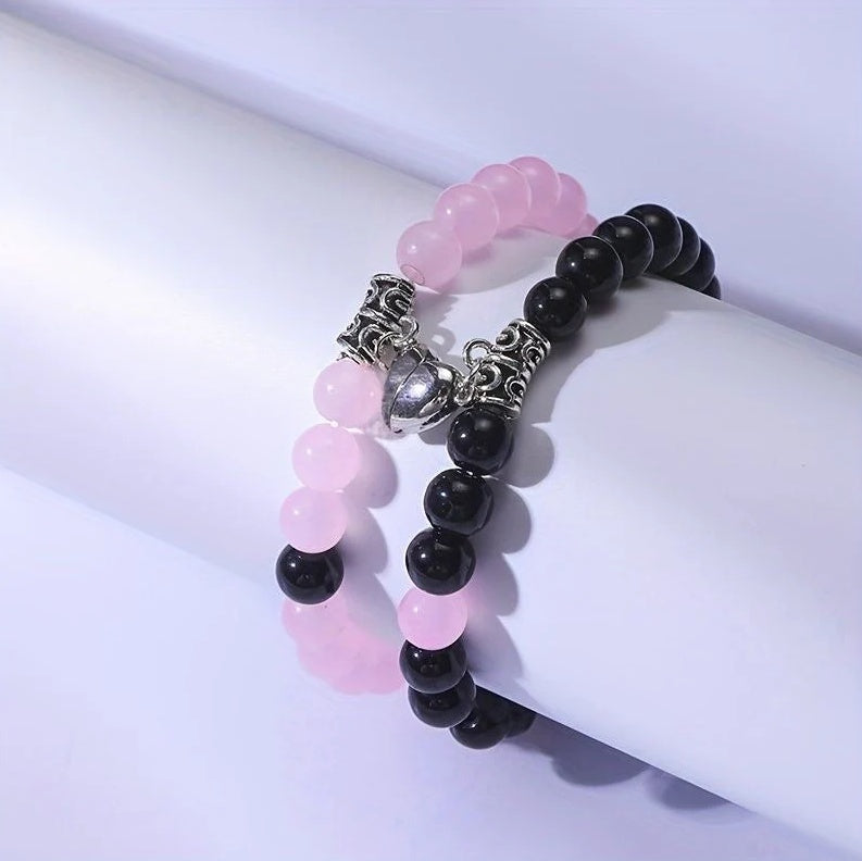 A Pair Of Pink And Black Beaded Bracelets, Perfect For Couples' Daily Wear Or As A Gift For Friends.
