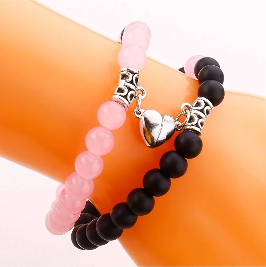 A Pair Of Pink And Black Beaded Bracelets, Perfect For Couples' Daily Wear Or As A Gift For Friends.