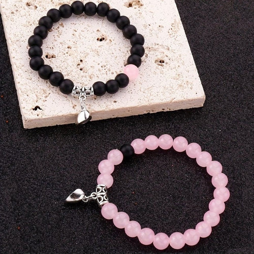 A Pair Of Pink And Black Beaded Bracelets, Perfect For Couples' Daily Wear Or As A Gift For Friends.